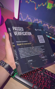 Person holding a FTMO 'Passed Verification' Award with a graph background