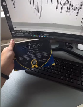 Person holding a Framed Funded Certificate from Funded Award in front of a computer monitor on a desk.