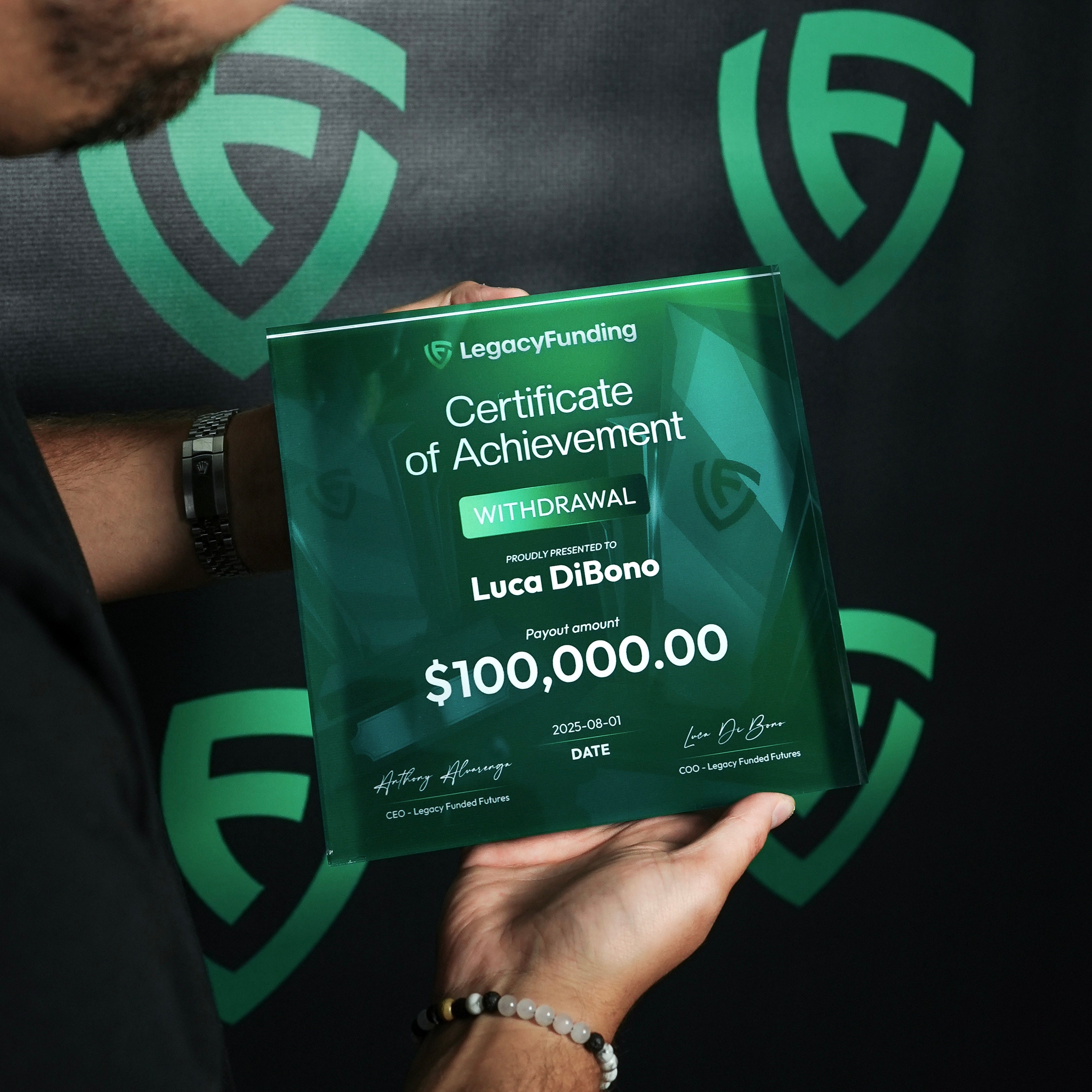 Luca holding a green plaque 'Certificate of Achievement' from LegacyFunding prop firm with a $100,000 withdrawal for Luca DiBono
