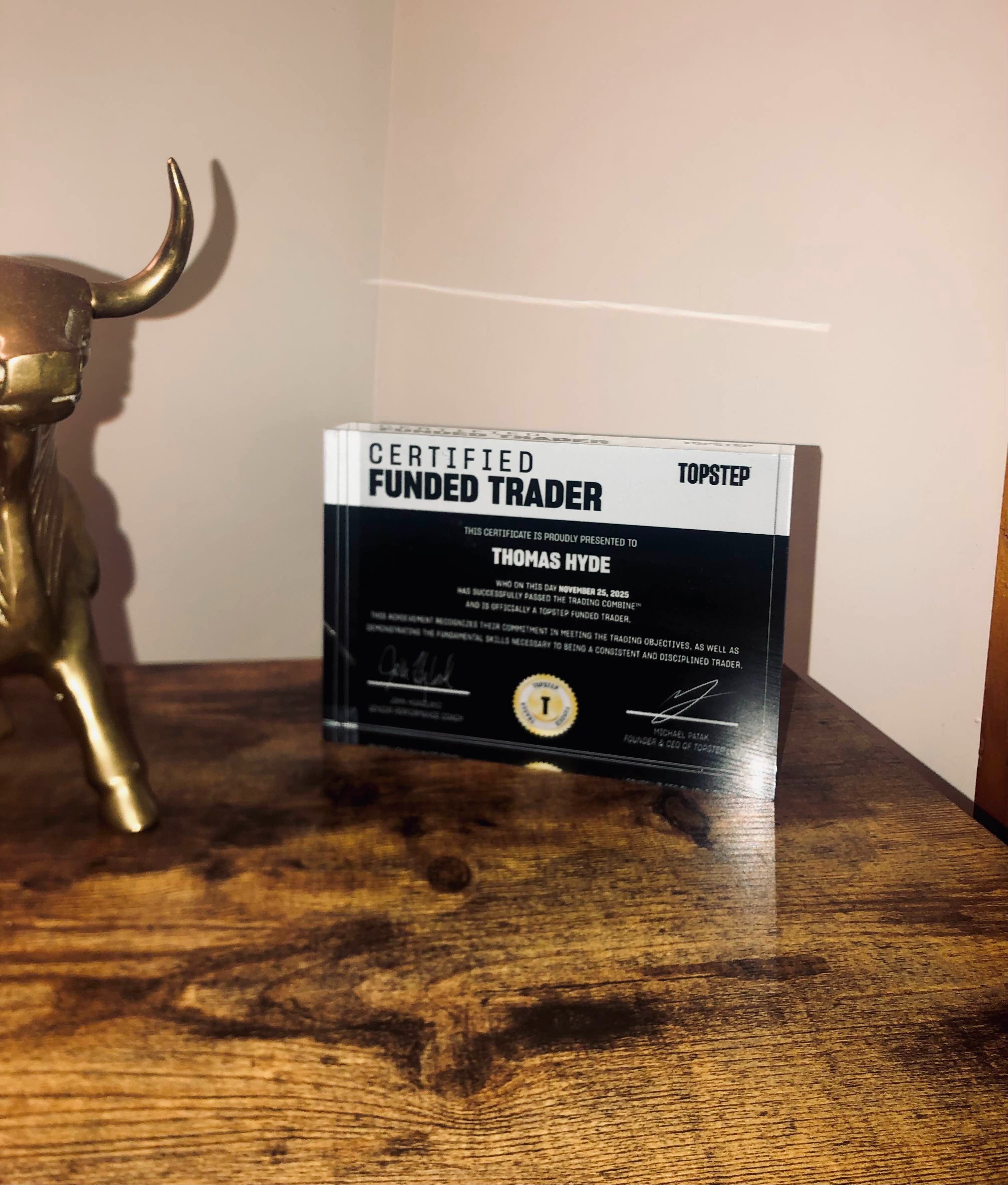 Funded Award acrylic plaque displaying a Topstep Certified Funded Trader certificate on a desk setup