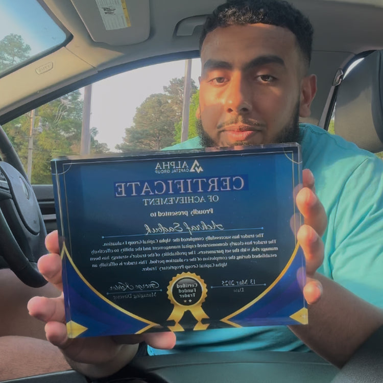 Man holding a blue Alpha Capital funded certificate made by Funded Award inside a car