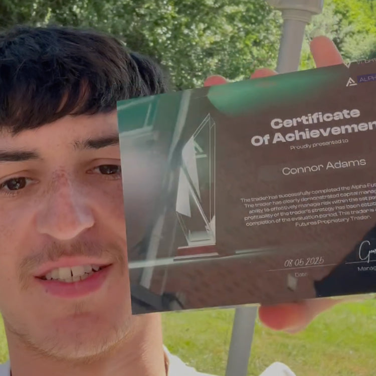 Person holding an Alpha Capital funded certificate outdoors