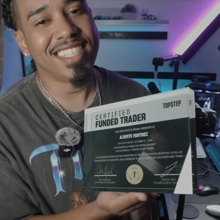 Man holding a TopStep'Certified Funded Trader' certificate made by funded awardin an indoor setting